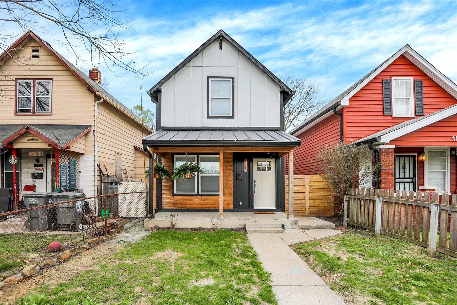 White board-and-batten front with cedar-accent porch on a Fountain Square street
