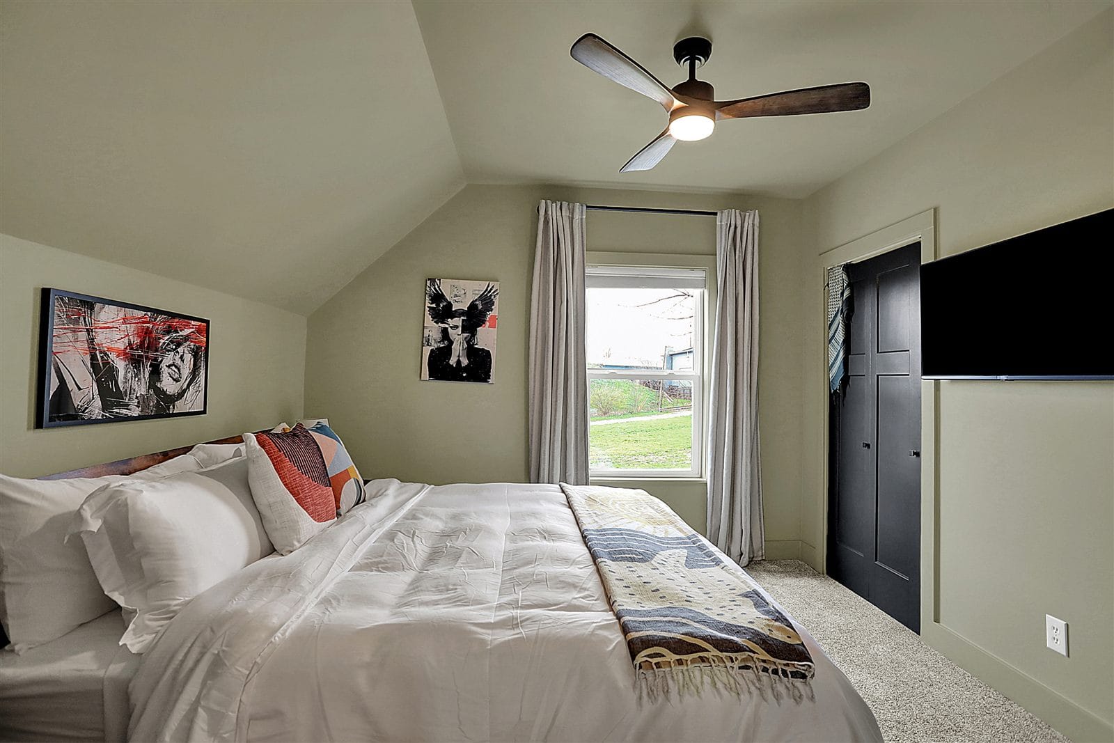 Third king bedroom with vaulted ceiling, olive-sage walls, wall TV, and closet