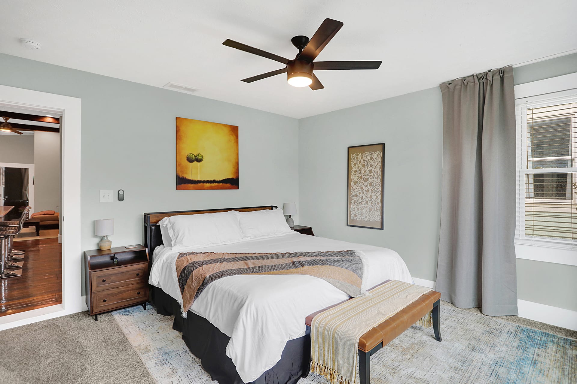 Third bedroom angle showing the king bed, ceiling fan, and doorway framing