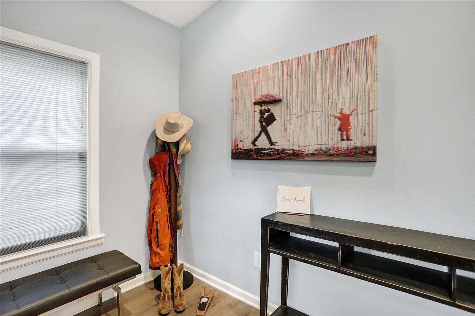 Living room looking toward entry and kitchen with gallery art wall and hardwood floors